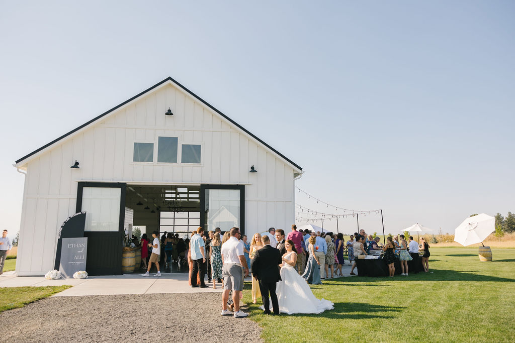 A view of a farmhouse on green bluff wedding cocktail hour taking place at sunset