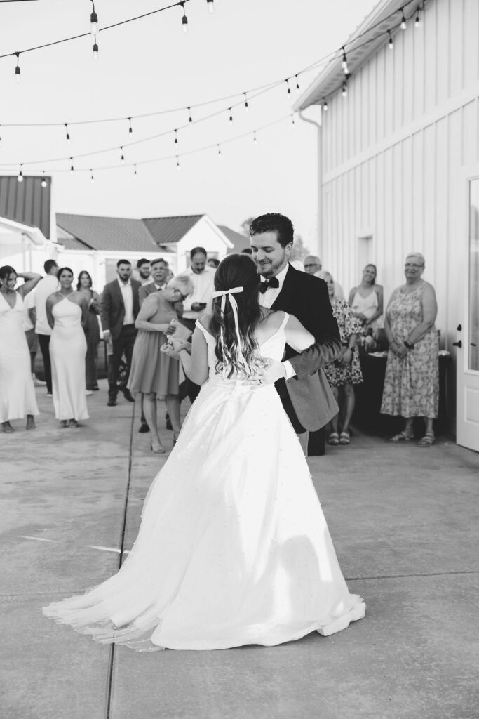 Newlyweds dance in black and white as guests watch