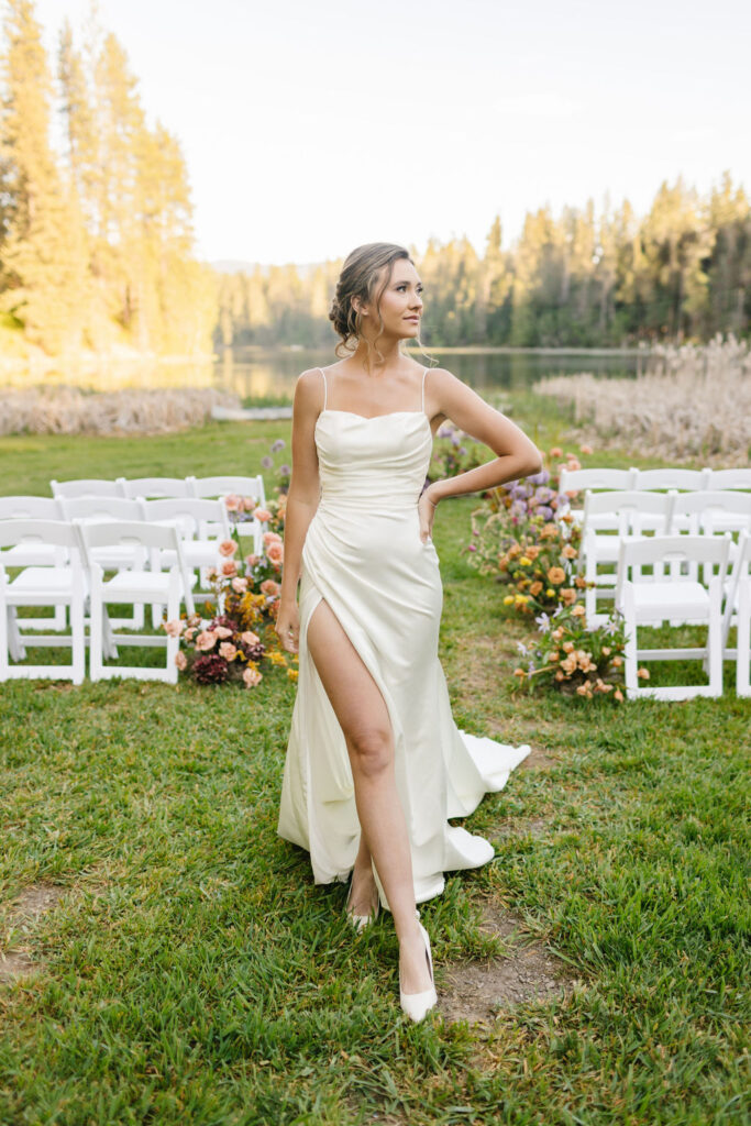 A bride struts in a silk dress up the aisle lined with flowers at one of the lakefront wedding venues coeur d'alene