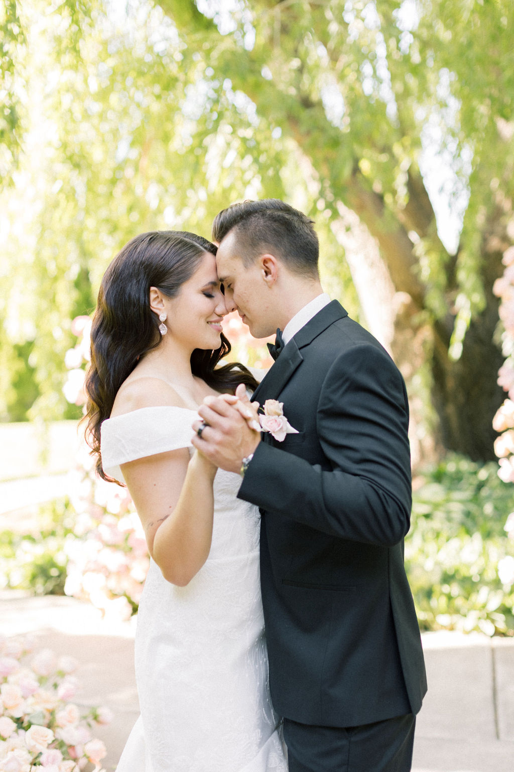 Newlyweds dance forehead to forehead on a sidewalk in the garden at promise garden pasco