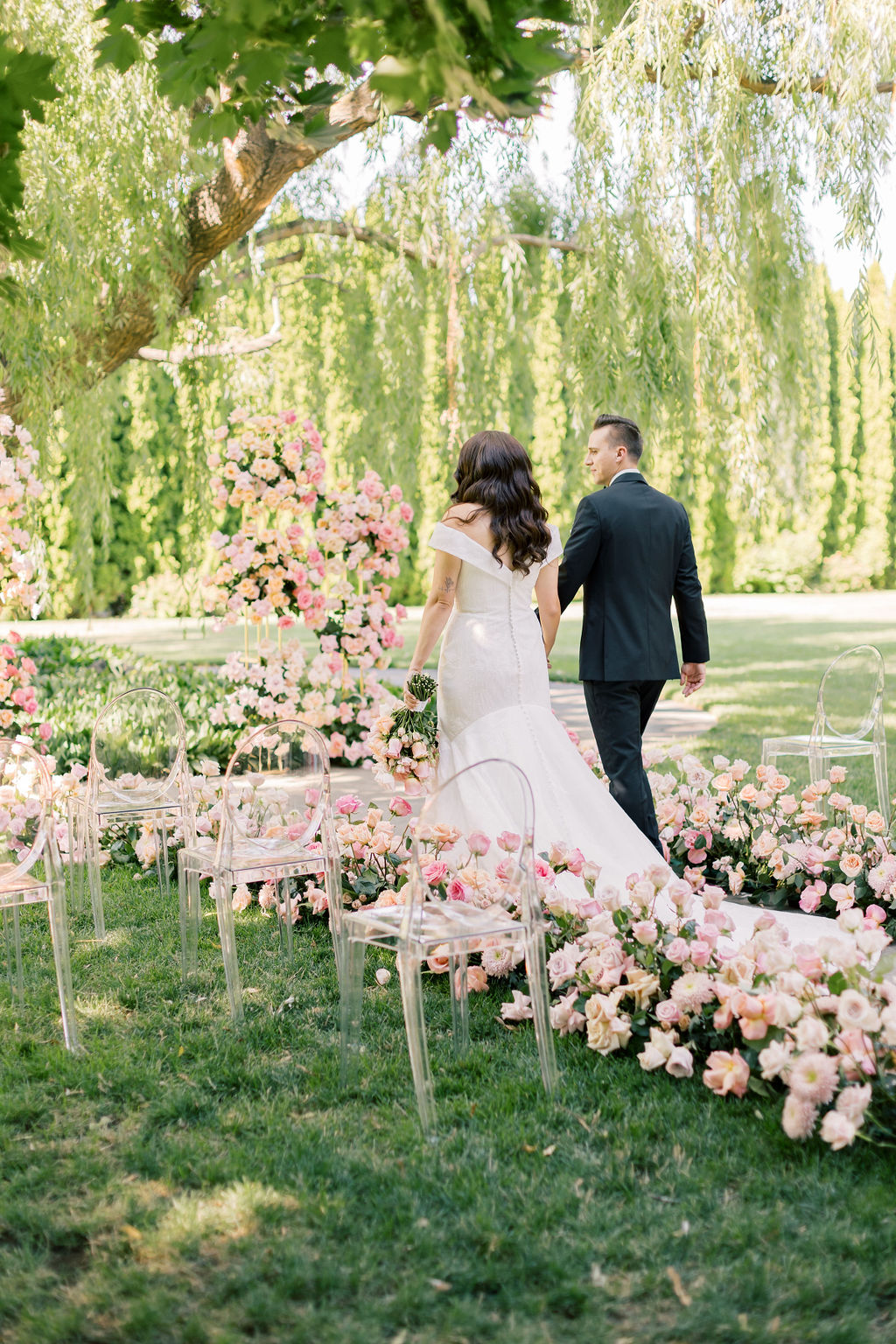 Newlyweds walk down the aisle holding hands after their ceremony in a garden