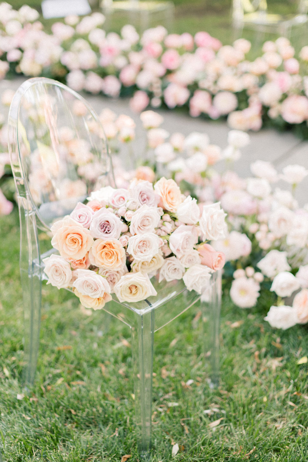 Details of a clear chair in a lawn with a large bouquet on it