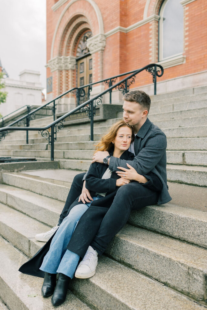 Newly engaged couple snuggles on some steps for a spokane engagement photographer