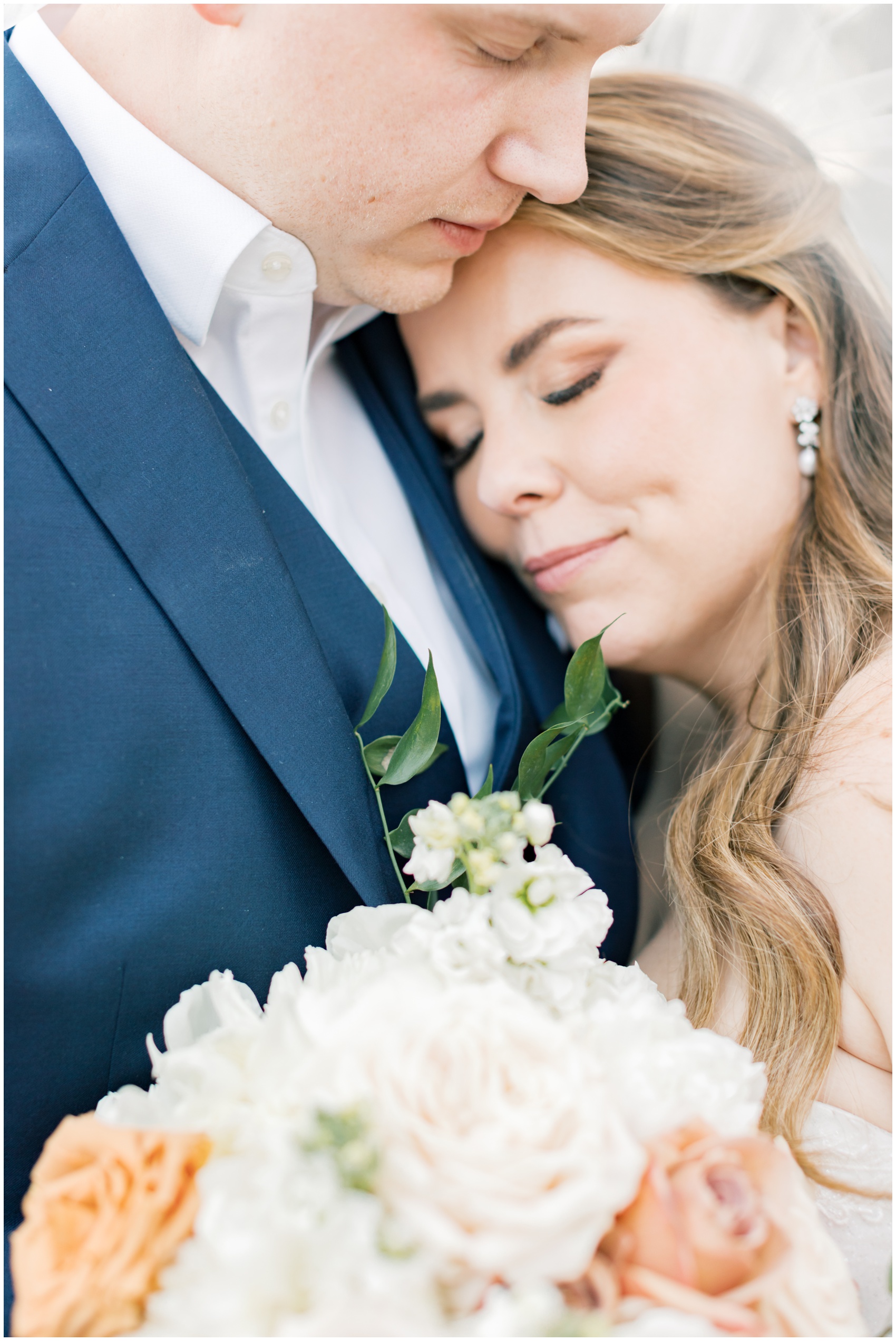 A bride snuggles on her groom's chest while holding her bouquet at their suncadia resort wedding