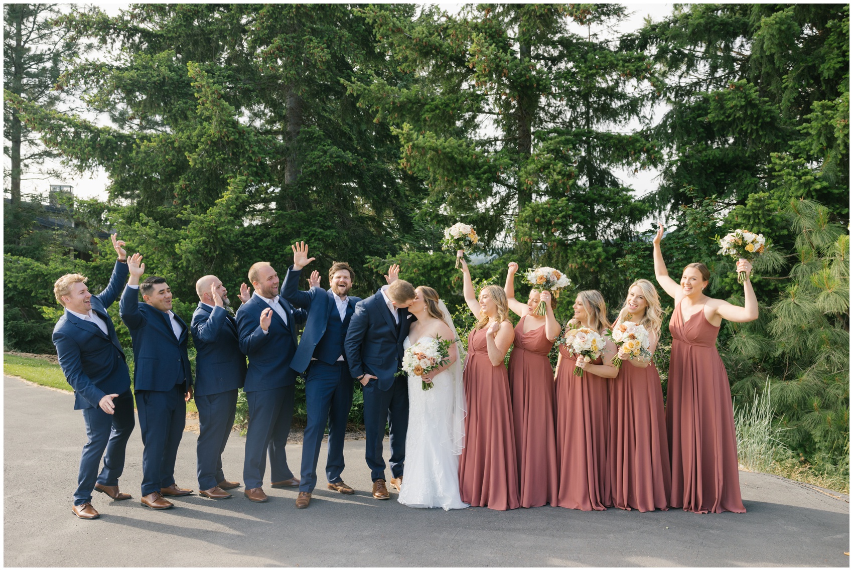 A bride and groom kiss while their wedding party celebrates around them at their suncadia resort wedding