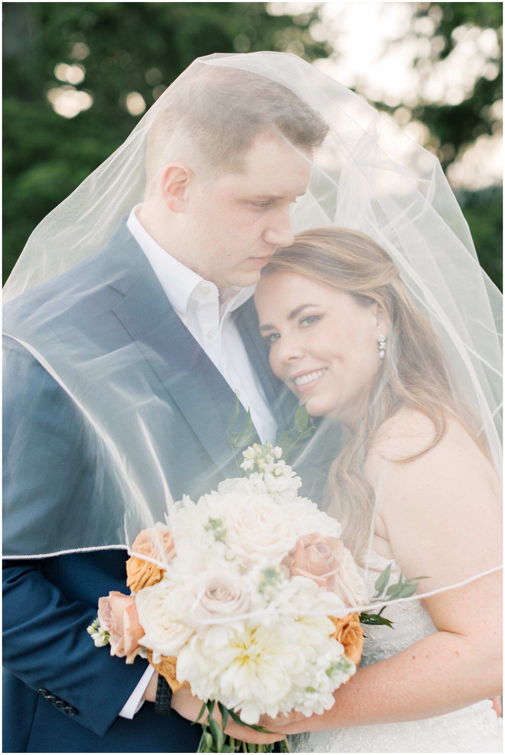 A bride and groom hide and snuggle under the veil at their suncadia resort wedding at sunset