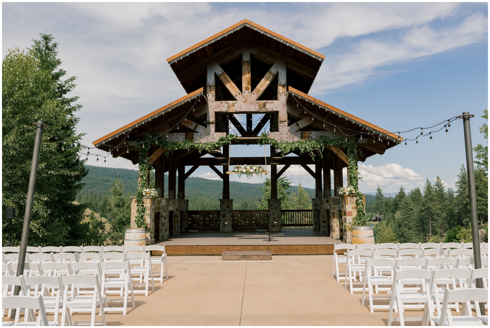 A view of an outdoor wedding reception under a large covered patio under market lights