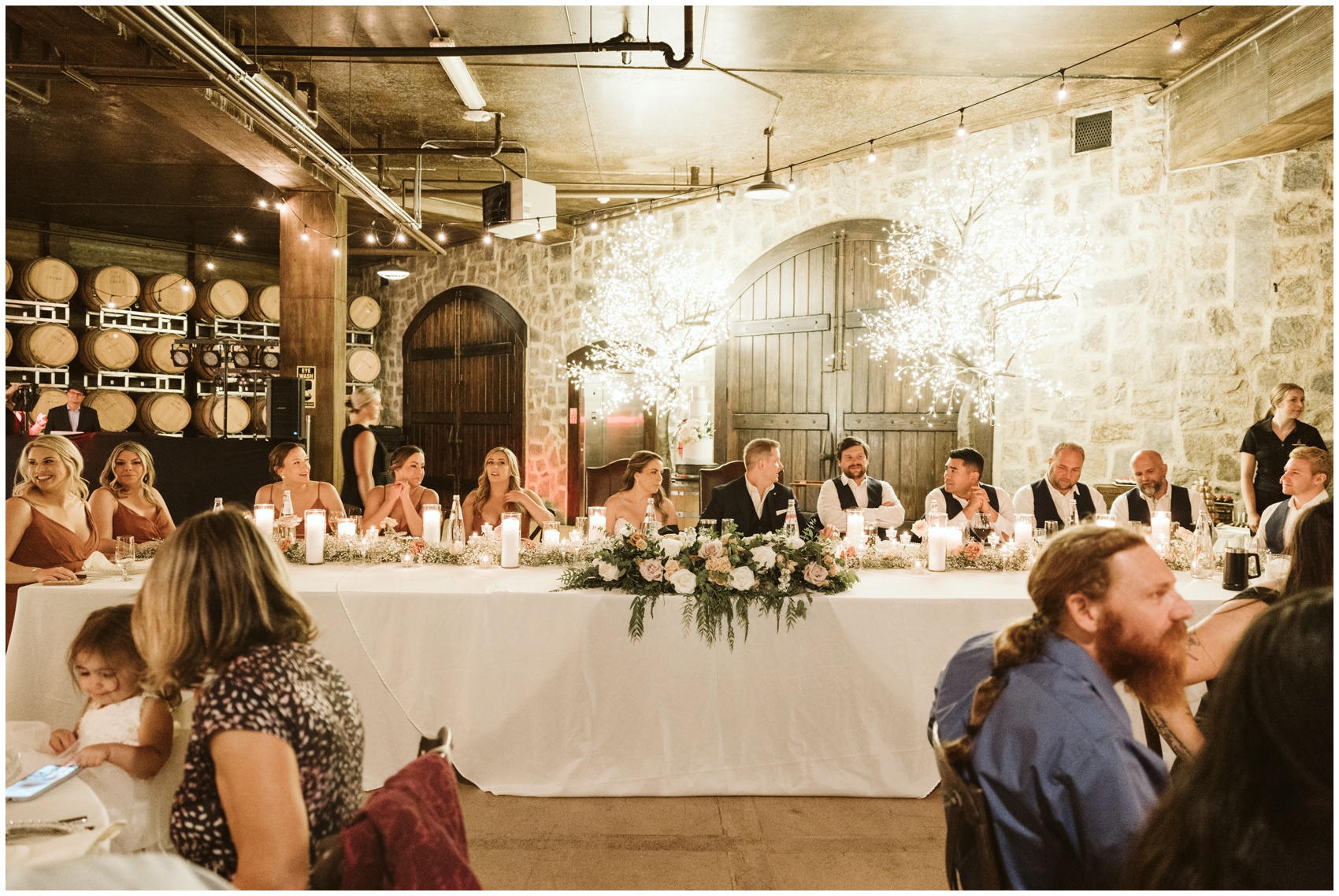 A look at a swiftwater cellars wedding reception head table with newlyweds and parties