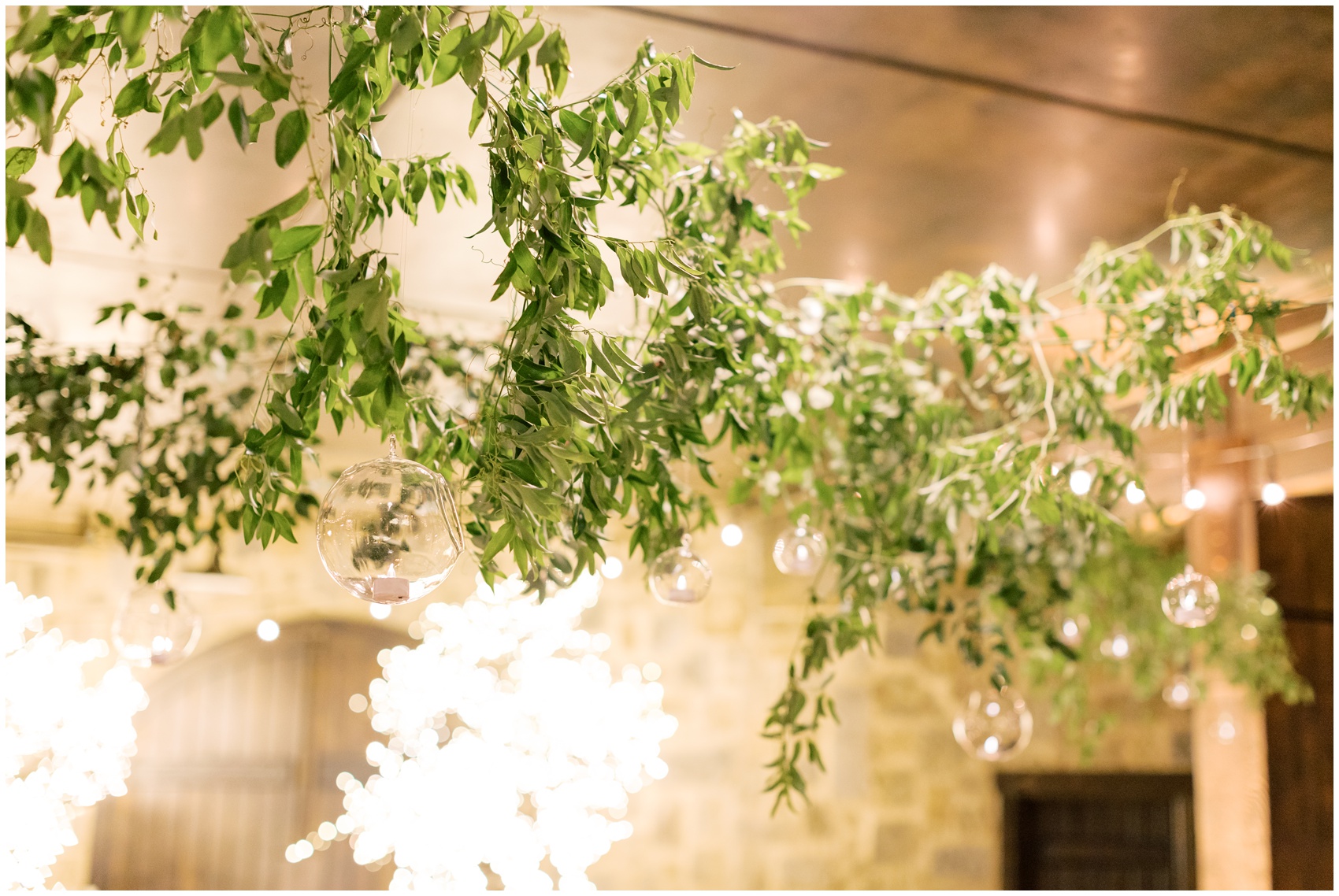 Details of greenery hanging on market lights at the swiftwater cellars wedding venue