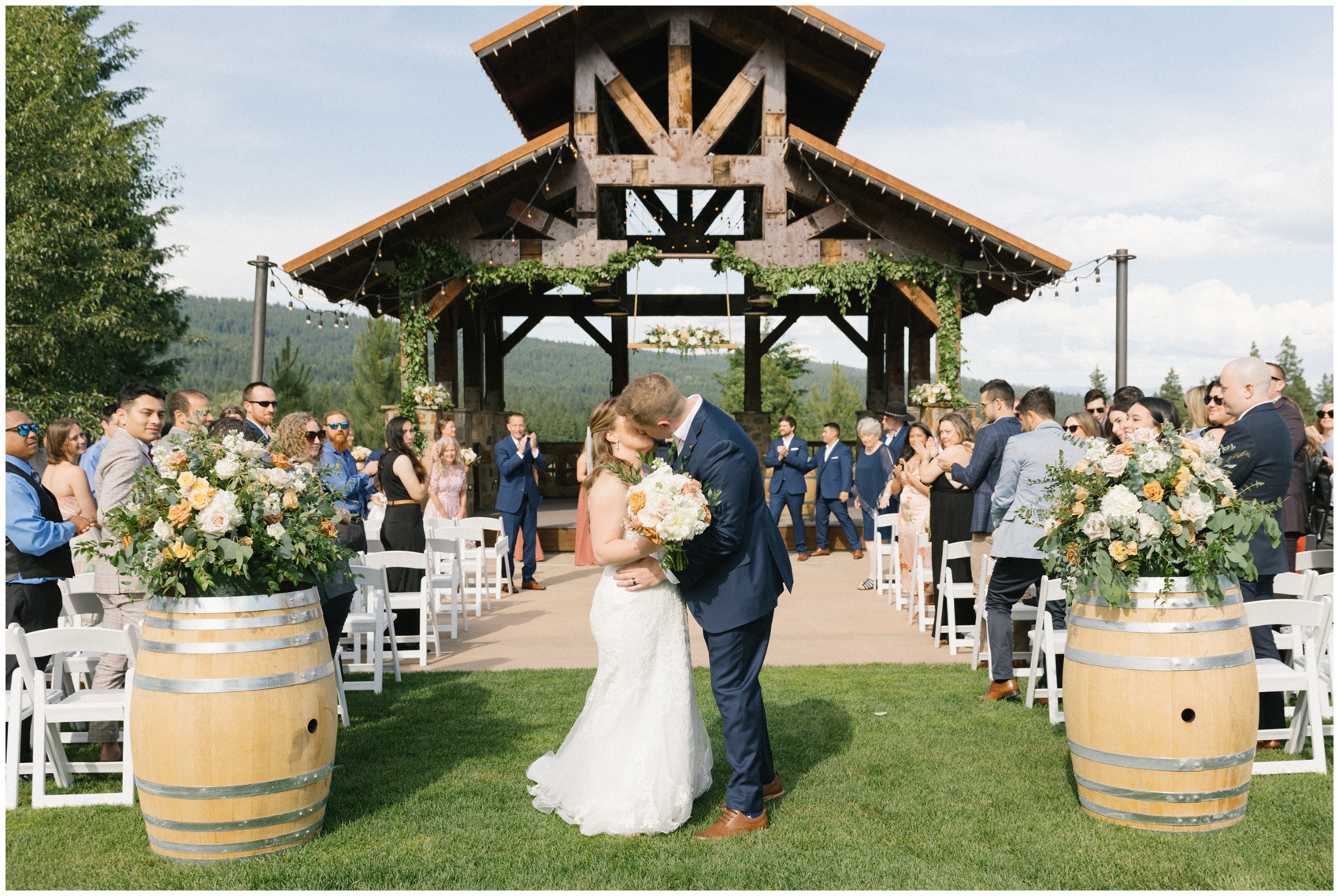 Newlyweds kiss at the end of the aisle to applause from their ceremony