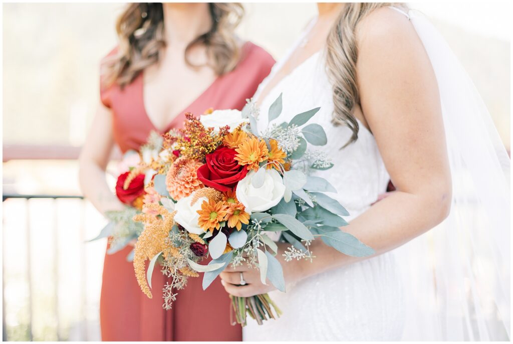 Details of a bride's colorful bouquet as she holds it