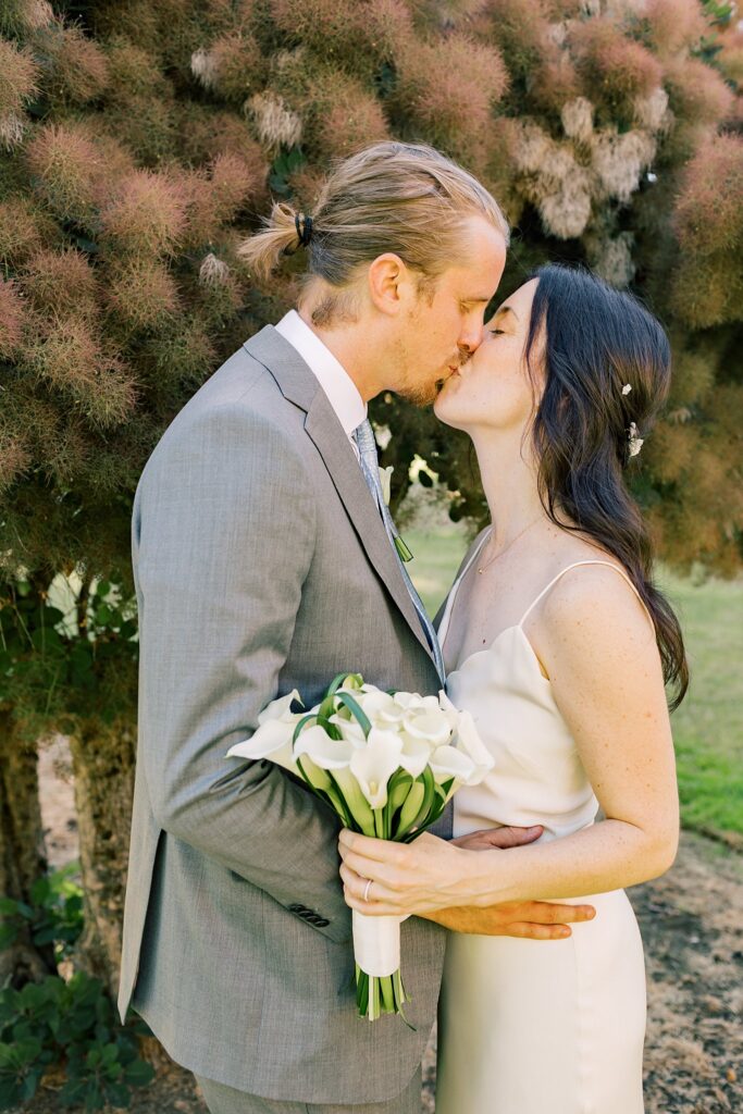 Newlyweds kiss in a garden