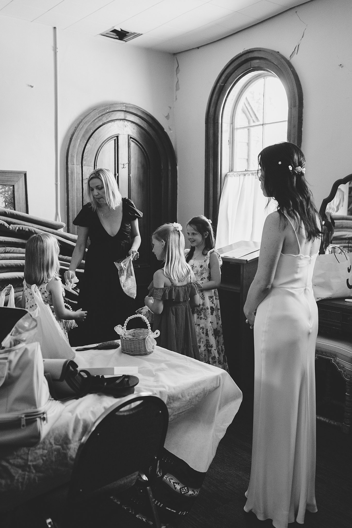 A bride gets ready with some young girls at the fort sherman chapel