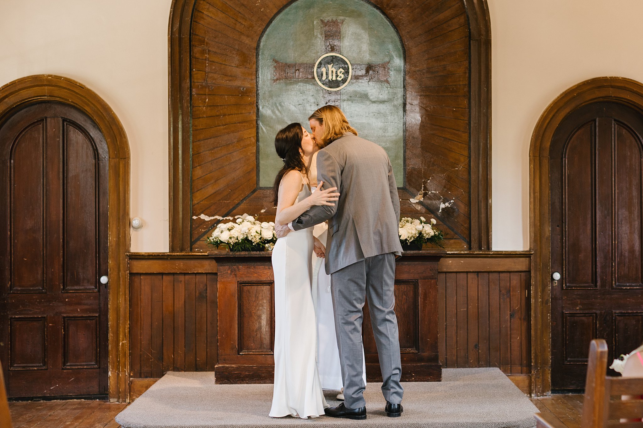 Newlyweds kiss at the altar to end their ceremony