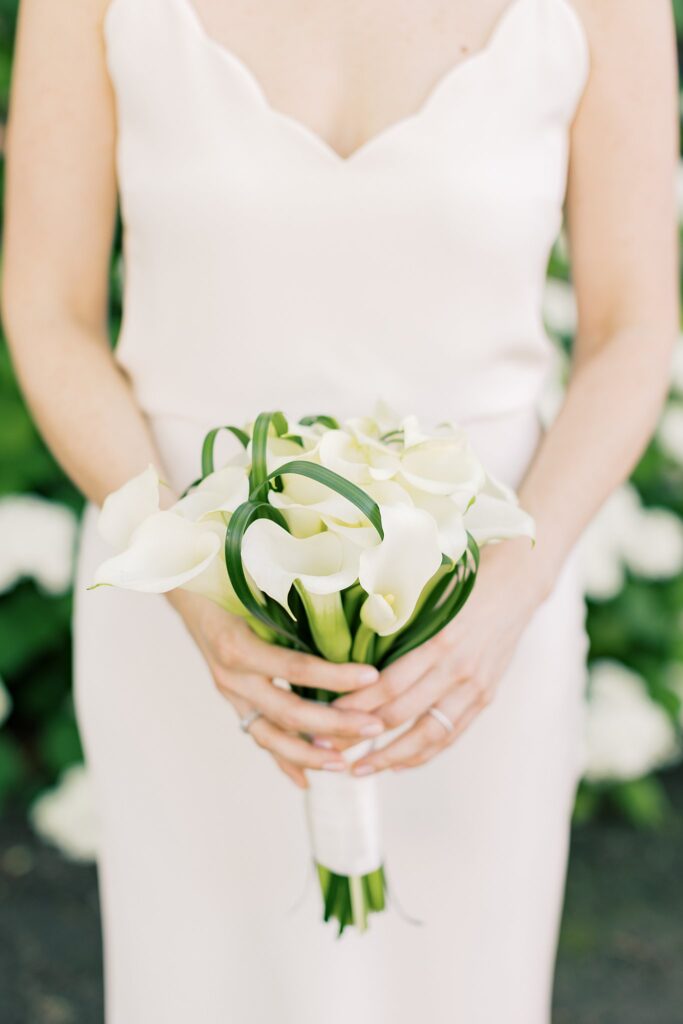 Details of a bride holding her white bouquet